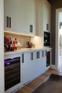 a kitchen with white cabinets and an oven built into the side of the countertop