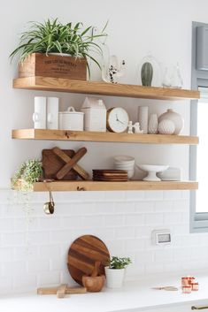 the shelves above the kitchen sink are filled with dishes and utensils for cooking