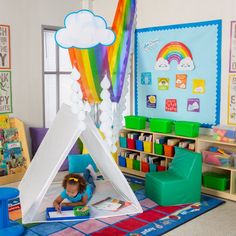 a child's playroom with a teepee tent and rainbow decorations on the wall