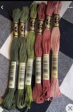 four skeins of yarn sitting on top of a checkered table cloth next to each other