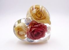 three roses in a glass vase on a white background