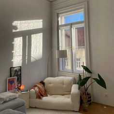 a living room filled with furniture and a lamp on top of a hard wood floor