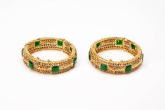 Timeless is the word for this Gold-tone plated set of cuff bangles that features a sophisticated setting of square crystals in a vibrant emerald color. Framed in sparkling clear zircon lines, it heavenly combines with a vast variety of attire to bring on that bling. Pair it with a watch or add bangles to form a bridal set, choice is all yours. Rectangular Gold Jewelry For Ceremonial Occasions, Rectangular Gold Ceremonial Jewelry, Ceremonial Gold Rectangular Jewelry, Traditional Gold Jeweled Bangle, Gold Jeweled Bangle For Wedding, Gold Bangle With Jewels For Weddings, Festive Gold Bracelets With Stone Setting, Traditional Gold Bangle With Jewels, Gold Wedding Bangle With Jewels