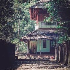 a small house in the middle of some trees and dirt path leading up to it