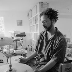 a man sitting in front of a drum set