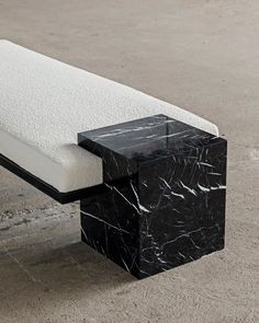 a black and white marble bench sitting on concrete