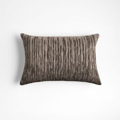 a brown and black striped pillow on a white wall