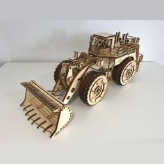 a wooden model of a tractor with plow attachments on the front and side