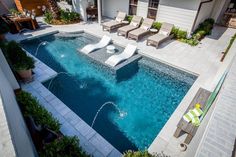 an aerial view of a swimming pool with lounge chairs