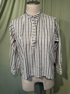 This is an adorable vintage blouse from the 60s or so. Labeled Gordon Peters, Man Tailored. No size tag. The bust measures 40" with measurements below. Made of a black & white cotton blend in a vertical stripe pattern. The pullover blouse closes down the front bodice with plastic buttons. The blouse has long sleeves with button cuffs. Hem is straight with small vents on the side seams. The collar has two buttonholes at the top for a button link or other pin type closure, which is not included. The inside of the collar has 3 small buttons, most likely had some sort of removable tie at some point in time.    The blouse is in very good condition!  No damage. No stains or soil. Super cute!  If you have never worn vintage before, please measure yourself!! Vintage sizes run smaller than today's Classic Top With Striped Collar For Daywear, Classic Striped Tops For Daywear, Cotton Gingham Top For Daywear, Daywear Top With Striped Collar, Striped Collared Blouse With Placket, Retro Collar Top For Fall, Retro Long Sleeve Top With Striped Collar, Gingham Button-up Tops For Daywear, Classic Plaid Tops For Daywear