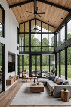 a living room filled with lots of furniture next to large glass windows on the wall