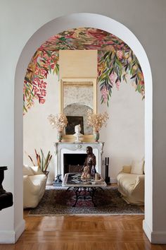 a living room filled with furniture and a painting on the wall above a fire place