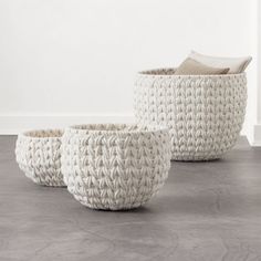 three woven baskets sitting on the floor next to each other