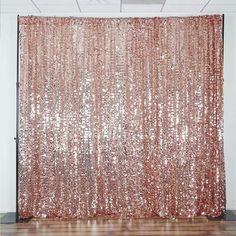 an orange sequin curtain hanging on the side of a wall in front of a wooden floor