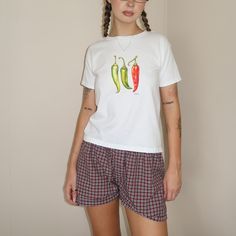 Turn up the heat with our Chili Pepper Baby Tee! This hot number features a trio of brightly colored chili peppers that add a kick of style to any casual look. Revamp your wardrobe with Everlace Designs' exclusive collection of essential tees, cozy hoodies, and playful baby tees in signature prints. Shop now for vibrant, cheeky designs perfect for any casual occasion. Elevate your everyday style with Everlace! Disclaimer: Product Images  Please note that the images displayed are digital mock-ups Red Graphic Print Tops For Loungewear, Retro Cotton Tops For Loungewear, 90s Style Relaxed Fit Cotton Top, Cute Red Relaxed Fit Top, 90s Style Red Cotton Shirt, Red Y2k Style Cotton T-shirt, Y2k Style Cotton T-shirt With Fruit Print, Y2k Relaxed Fit T-shirt With Funny Print, Red Y2k Cotton T-shirt