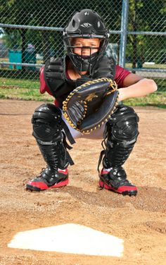 a baseball player kneeling down with his catcher's mitt in front of him