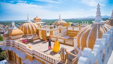 a woman standing on top of a yellow and white building