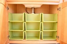 an open cabinet with several bins in it and the words 13 use stacking bins under the sink