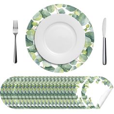 a white plate with green leaves on it next to a fork, knife and spoon rest