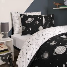 a bed with black and white space themed sheets