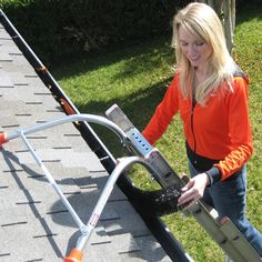 a woman standing on top of a roof next to a metal hand rail and ladder