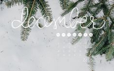 a desktop calendar with the word december written in cursive font and evergreen branches