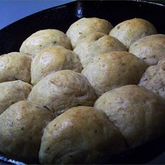 a black bowl filled with rolls on top of a table