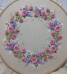 an embroidered wreath with pink and purple flowers