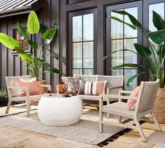 a living room filled with lots of furniture and plants