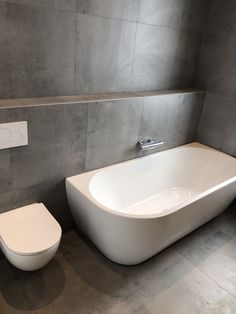 a white bath tub sitting next to a toilet