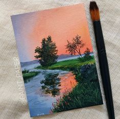 a painting with a brush sitting on top of it