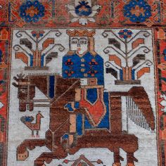 an old rug with a man riding a horse on it's back in the middle