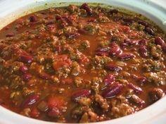 a white crock pot filled with chili and meat