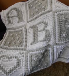 a white crocheted blanket sitting on top of a bed