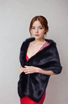 a woman in a red dress is wearing a black fur shawl and posing for the camera