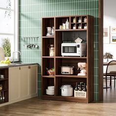 a kitchen with green walls and wooden flooring next to an open bookcase filled with dishes