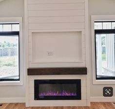 a modern fireplace with two windows in the background