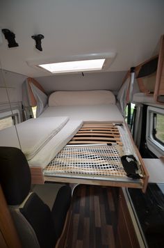 the interior of a camper with a bed and mattresses on it's side