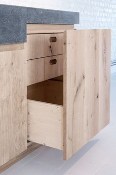 a wooden cabinet with two drawers and one door open