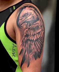 an eagle tattoo on the back of a woman's shoulder and arm, with black ink