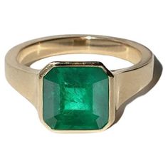 a gold ring with an emerald stone in the center