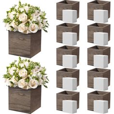 a bunch of white flowers sitting in a wooden box next to each other on a white background