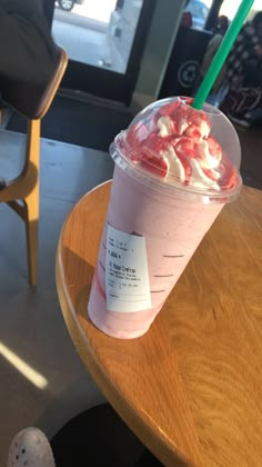 a drink with strawberries in it sitting on top of a table next to a chair