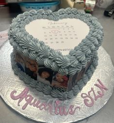 a heart shaped cake with photos on the front and sides, sitting on top of a table