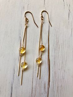 Tiny sparkly citrine coins dangle on a gold filled chain and ear hook. Stone size 5-6mm Length 3 inches MATERIAL: GOLD-FILLED - 14k Gold filled is considerably durable and considered a lifetime piece of jewelry. This is NOT gold plated or gold dipped vermeil jewelry which can chip off over time with wear. Gold filled metal is essentially a 14k gold tube filled with an inner core metal such as brass and has been mechanically bonded with high very hot heat. It will never chip or flake off such as Handmade Gold Long Drop Crystal Earrings, Gold Long Drop Crystal Earrings For Jewelry Making, Gold Long Drop Crystal Earrings Nickel Free, Gold Nickel-free Long Drop Crystal Earrings, Handmade Dainty Gold Crystal Earrings, Nickel-free Citrine Dangle Jewelry, Gold Wire Wrapped Dangle Crystal Earrings, Gold Jewelry With Dangling Beads In 14k Gold Filled, Yellow Gold Citrine Dangle Earrings