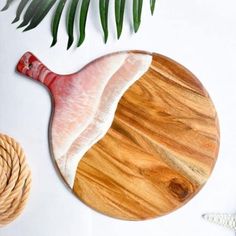 a wooden cutting board sitting on top of a table next to a rope and starfish