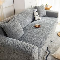 a couch with pillows and a stuffed animal on it