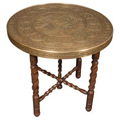 a wooden table with an intricate design on it's top and two braided legs