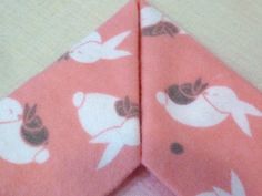 an orange tie with white birds on it is laying on top of a pink cloth