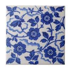 a blue and white tile with flowers on it